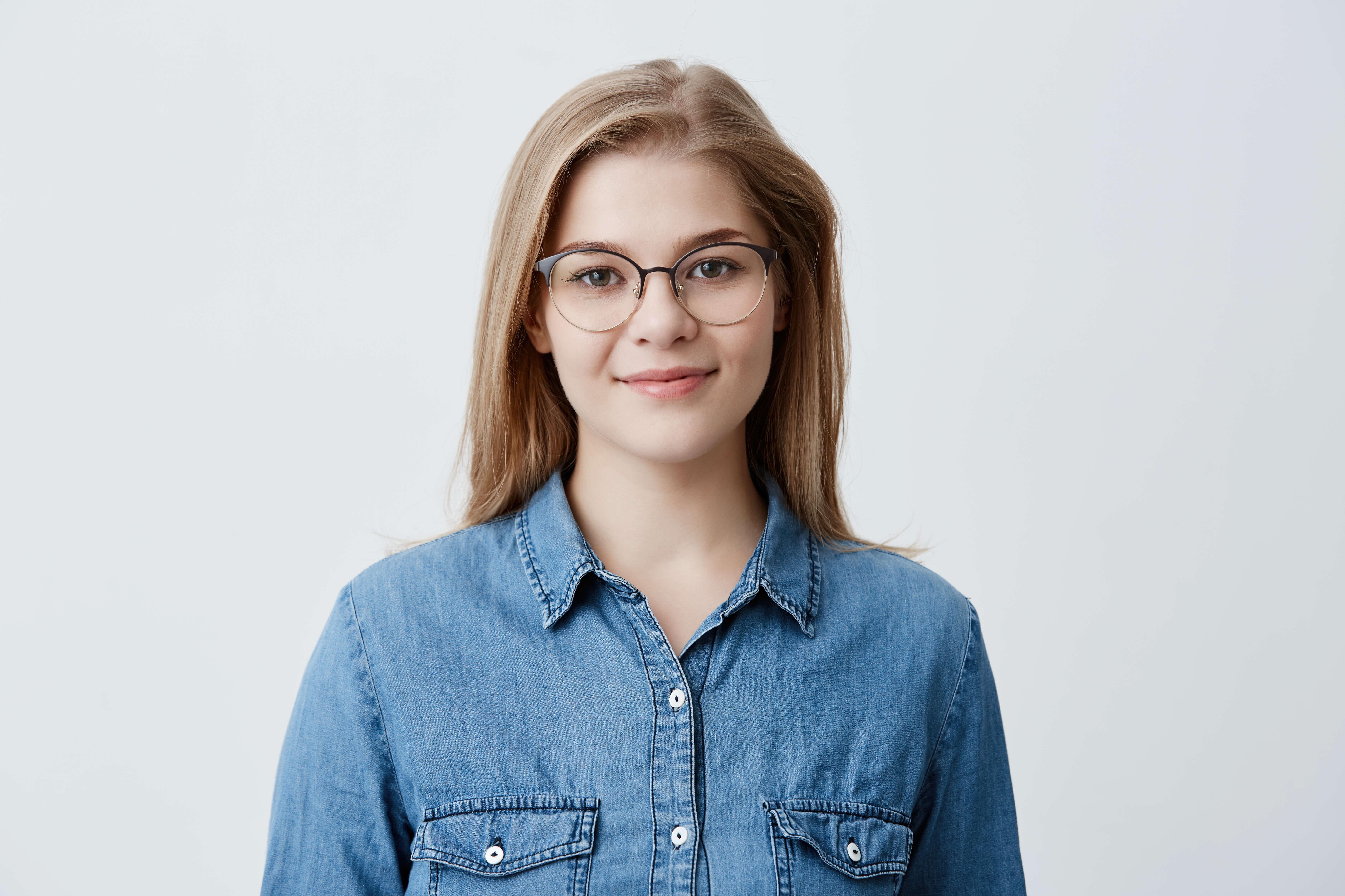 horizontal-portrait-smiling-happy-young-pleasant-looking-female-wears-denim-shirt-stylish-glasses-with-straight-blonde-hair-expresses-positiveness-poses.jpg